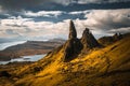 Large pinnacle of "Old Man of Storr" rocks against a cloudy sky in Scotland