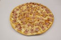 Large pizza with lots of bacon pieces of the same size placed almost mathematically on top of the melted mozzarella cheese