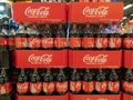 Large plastic bottles of Coca Cola soft in boxes in a supermarket.