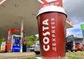 Large plastic Costa Coffee cup standing at a Esso petrol station. Royalty Free Stock Photo