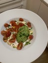 Large plate of creamy cheese with olive oil, sliced ripe avocado, tomatoes cut in half, healthy food, fresh vegetables and dairy p