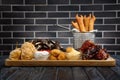 Large plate with a wide selection of snacks for beer in bar.