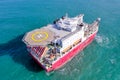 Large Platform supply ship with Helipad and two large cranes, anchored at Sea.