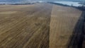 Large plowed field plowed land, yellow dry straw after harvesting wheat, lake