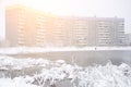 Large pond near a multi-storey building in winter covered snow