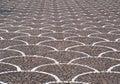 Large porphyry paving with semicircular decorative motifs in white stone cubes