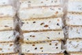 Large portions of home made Nougat confectionary made with sugar or honey, almonds and dried fruits, covered in plastic, displayed