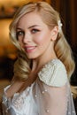 A large portrait of a beautiful blonde and sexy bride with an attractive body, with curls and a pearl hairpin. Morning of the