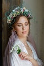 A large portrait of a beautiful bride with her eyes closed with a wedding hairstyle and makeup with a veil and a wreath of flowers Royalty Free Stock Photo