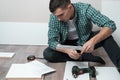 Large portrait of a man sitting on the floor of the room with tools collect furniture according to instructions Royalty Free Stock Photo