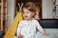 a large portrait of a small laughing girl in a room.