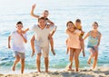 Large family happily running and carrying kids on parents back