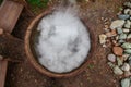 A large pot or pan over a fire while preparing a potion or meal, evaporating a large amount of steam while boiling water. Mystical Royalty Free Stock Photo