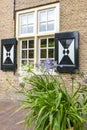 Large pots with white and purple agapanthus flowers in front of a window with beautiful shutters near Bouvigne Castle at Breda, Ne