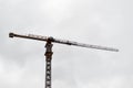 Large powerful construction cargo industrial crane on a construction site of new buildings and houses against the sky