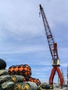 Large powerful Crane of a Harbor or Port and different types of ship fenders or ship tire bumpers to be used on moored ships. Royalty Free Stock Photo