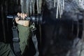 A large powerful flashlight in a womanÃ¢â¬â¢s hand against the background of ruins, photo with weak lighting