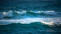 Large Powerful jade turquoise colored waves crashing at Sennen Cove in Cornwall during late sunset Royalty Free Stock Photo