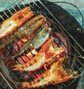 Large prawns are placed on an iron griddle and grilled over a hot coal stove Royalty Free Stock Photo