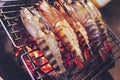 Large prawns are placed on an iron griddle and grilled over a hot coal stove Royalty Free Stock Photo