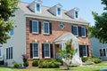 Large private brick country house with a green trimmed lawn. Sunny summer day and blue sky