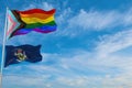 large progress lgbtq flag and flag of Maine state, USA waving in the wind at cloudy sky. Freedom and love concept. Pride month.