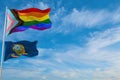 large progress lgbtq flag and flag of Idaho state, USA waving in the wind at cloudy sky. Freedom and love concept. Pride month.