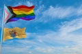 large progress lgbtq flag and flag of New Jersey state, USA waving in the wind at cloudy sky. Freedom and love concept. Pride