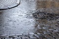 Large puddle on a cobbled street in the old town. Raindrops on the surface of a puddle