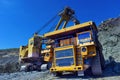 Large quarry dump truck. Loading the rock in the dumper. Loading Royalty Free Stock Photo