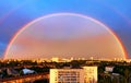 Large rainbow in the evening cityscape in the evening sky