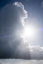 Large rainy cumulus cloud against the bright sun and sky. Abstract background.