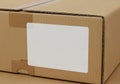 A large, rectangular cardboard box with a corrugated texture is shown. The box is sealed and has a Royalty Free Stock Photo