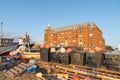 Large red brick apartment building along waterfront is background to collection of fishing gear and boats on beach Royalty Free Stock Photo