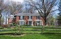 Large Red Brick Country Home with Split Rail Fence Royalty Free Stock Photo