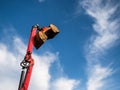 A large red construction excavator bucket over blue sky ready for quarrying Royalty Free Stock Photo