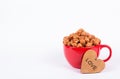 Large red cup of sweet chocolate popcorn. Caramel popcorn in red mug on white background. Popcorn and heart. Royalty Free Stock Photo