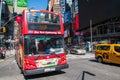 Large red double decker sightseeing tour bus full of tourists seen on Broadway in Times Square Manhattan, New York City