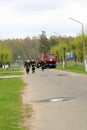 A large red fire rescue vehicle, a truck to extinguish a fire and male firefighters at a chemical, oil refinery against the backgr