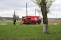 A large red fire rescue vehicle, a truck to extinguish a fire and male firefighters at a chemical, oil refinery against the backgr