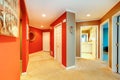 Large red hallway in city apartment with open bathroom door and beige carpet. Royalty Free Stock Photo