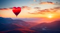 A large, red, heart-shaped balloon flies high in the clouds over the mountains at sunset. An unusual gift for a holiday