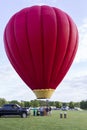 A Large Red Hot Air Balloon Just Above The Ground