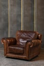 a large red leather chair against a textured wall. the interior of the loft has a dark floor Royalty Free Stock Photo