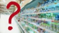 Large red question mark on abstract blur supermarket background. Defocused shelves with products. Grocery shopping. Store. Retail