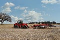 Large red tracked tractor getting ready to cultivate a field with a chisel plough Royalty Free Stock Photo