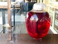 A large red transparent glass round luminous bright jar, the capacity of a delicious sweet juice, a hamper, a mors, wine, liquid s