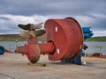 A large, red, twin propellor - twin screw screw azimuth thruster unit on the quay at Lerwick harbour in Shetland, UK.