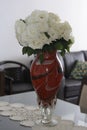 Large red vase on top of a glass table in the interior of a residential apartment