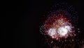 Large red, white, blue, and gold expanding fireworks with a black background